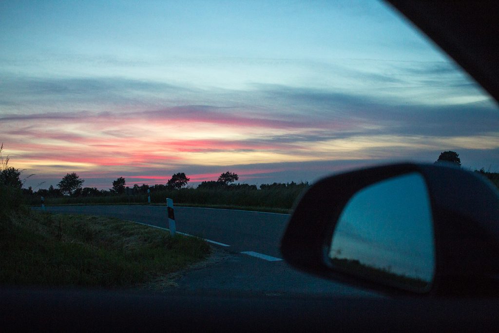 Blick aus dem offenen Autofenster bei Sonnenuntergang