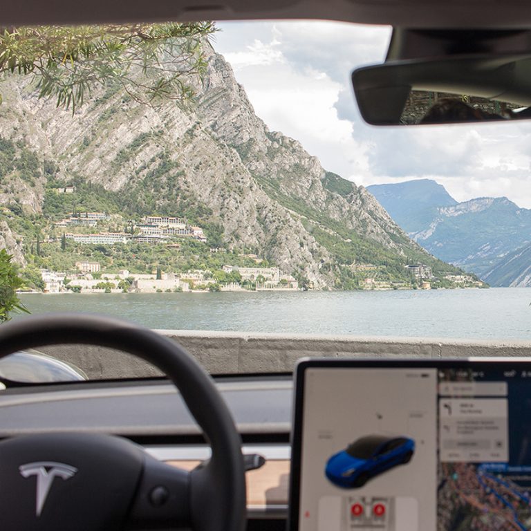 Blick aus der Windschutzscheibe eines Tesla Model 3 auf den Gardasee
